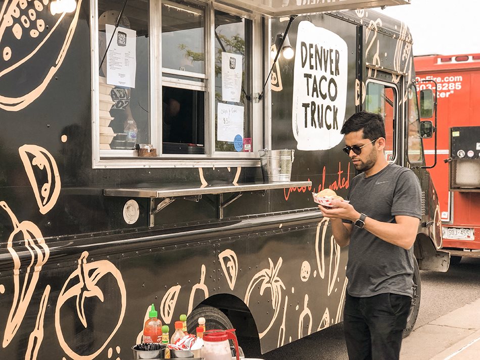 Man ordering food at a local taco truck, highlighting access to nearby food trucks and local eateries at 1443 Elizabeth in Denver, CO